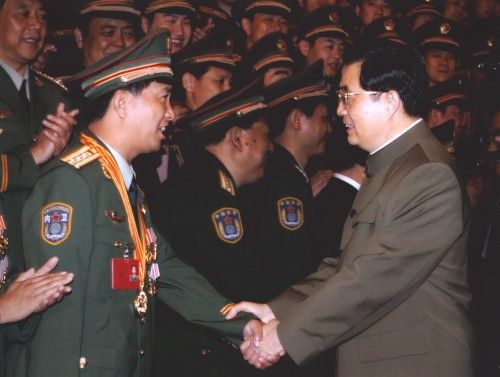 2005年6月22日,时任中共中央总书记、国家主席、中央军委主席胡锦涛与独臂英雄丁晓兵亲切握手。(资料图新华社)