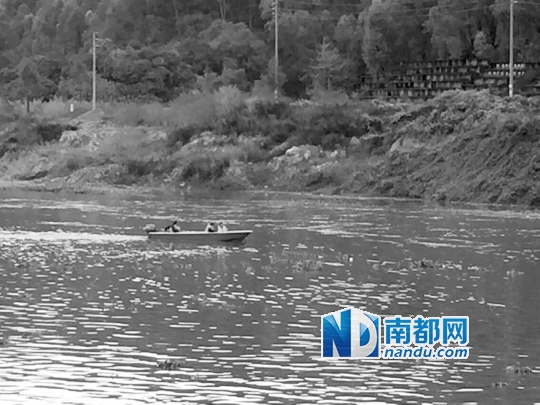 ↑消防队员正在搜索坠河失踪的两名工人。