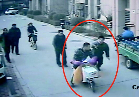 张某骑车欲逃走时被抓获。 视频截图