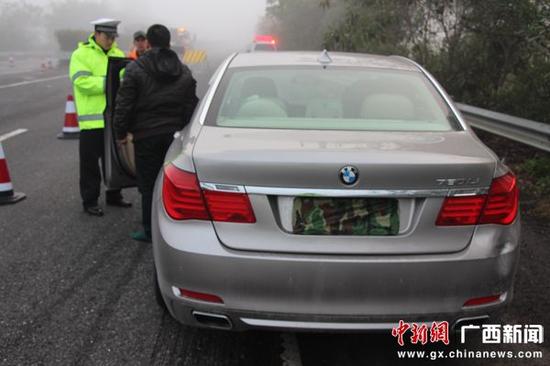 小轿车车尾号牌上的迷彩布很显眼。