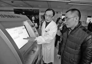 院方工作人员正在演示如何在自助挂号机上预约门诊分时段就诊。 记者 许天长 摄