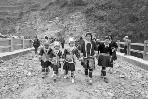 一群妇女和孩子穿着艳丽的民族服装,兴高采烈地从宁波桥上走过。 记者 范洪 摄