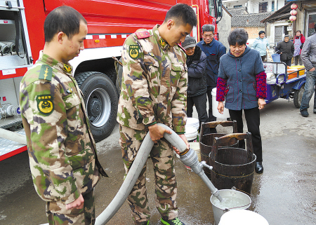 图为消防战士给村民送水。(骆承 摄)