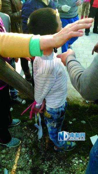 同伴菜地里偷西红柿,结果7岁的男孩小聪被菜农反绑在木桩上。