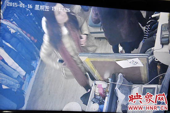 趁着一名店员转身，女子迅速将苹果手机装兜里，转身快速离开店面。