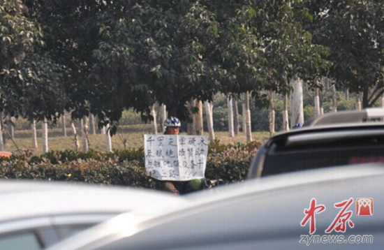 男子举着求助纸张沿街乞讨。