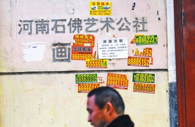 曾经的石佛艺术公社招牌已被搬家小广告﹃侵占﹄。