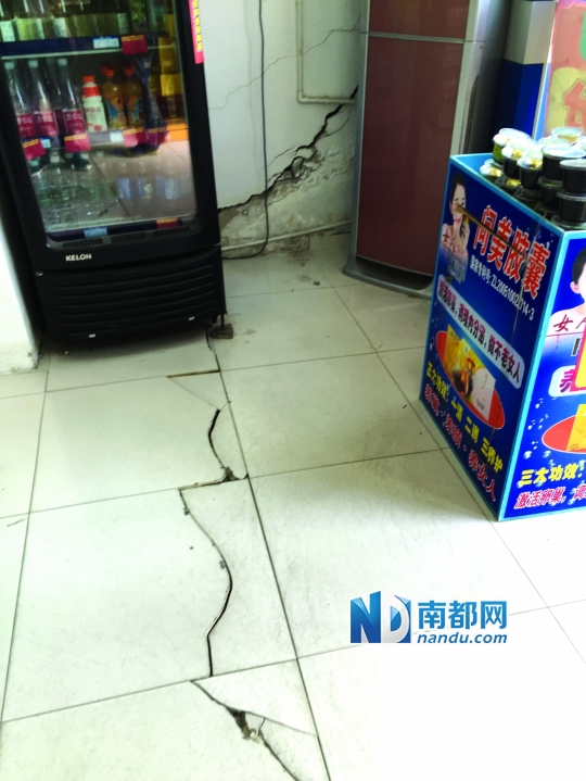 联邦广场一楼某店铺墙壁已经出现严重裂痕,地面瓷砖也出现开裂。