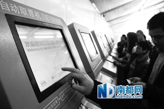 2015年1月24日,在广州火车站互联网自动取票点,一名旅客正在使用自动取票机取票。