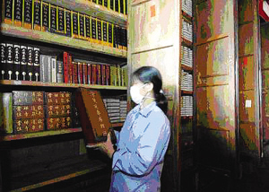 工作人员在福州鼓山涌泉寺藏经殿内检查经书的受潮情况