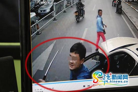 蓝衣男子持伸缩棍砸公交车挡风玻璃。