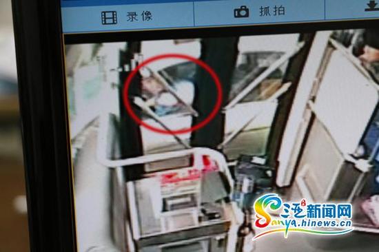 监控显示驾驶奔驰车的男子(红圈内)在红绿灯处敲打公交车前门。