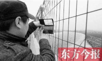 1月27日，有市民隔着铁丝网拍摄南水北调中线干渠的壮观