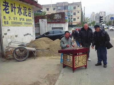 老叶在水泥店门口演奏扬琴和拉二胡