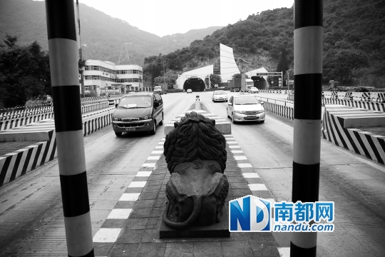 →一尊威严的石狮矗立在盐田坳收费站前面。未来,它将被移走。
