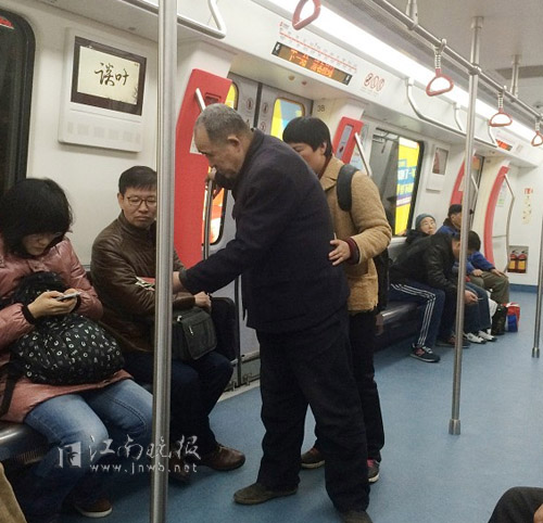 女乞讨者背双肩包,另一名中年男性手攥一把零钱,频频给乘客鞠躬,并讨要钱物