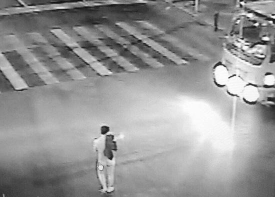 男子光着身子站在路口拦车