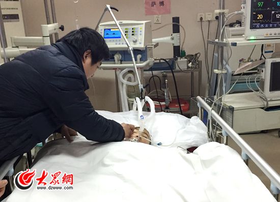 李志其接过妻子手中的纸巾，细心地为小建运擦拭脸颊，跟儿子做捐献手术前最后的告别。