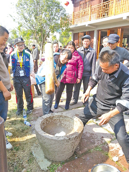 图为游客在毛岙村广场参与制作年糕。(曹爱方 摄)