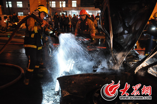 为防止火势死恢复燃,消防人员又掀起车辆引擎盖,对着火部位进行降温