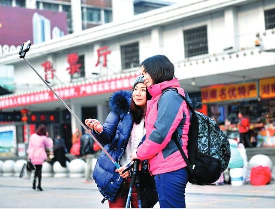 美女在株洲火车站用自拍神器拍照