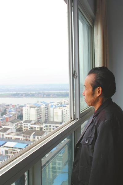 王本余在新居窗前眺望涪江。