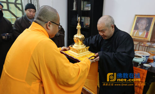 重庆缙云寺住持妙慧法师从涂山寺住持正勇法师手中接过惟贤长老舍利金塔