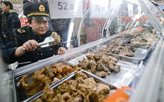 图为：武汉市食药监局执法人员抽检市场“年货”