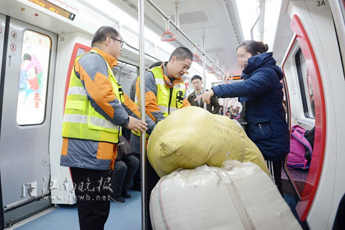 地铁工作人员帮忙把乘客的行李移至合理区域 清茶摄