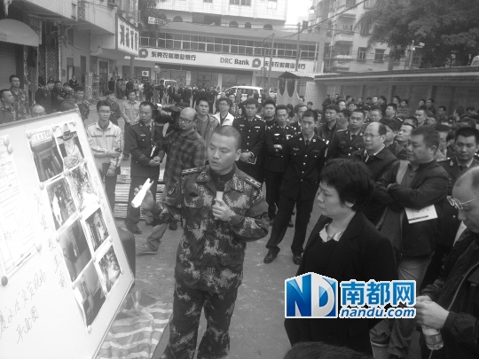 在发生火灾的药店门口,昨日召开了东莞全市消防安全现场会。图为消防工作人员介绍初步调查情况。南都记者 寇金明 摄