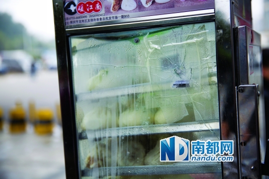 2月16日，深圳龙岗天虹商场附近一家便利店门口摆放的厨具玻璃被打穿。 南都记者 陈文才 摄