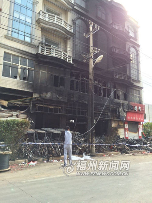 车行的两轮车都被烧得只剩下骨架了,事发楼房外墙也都被熏黑。