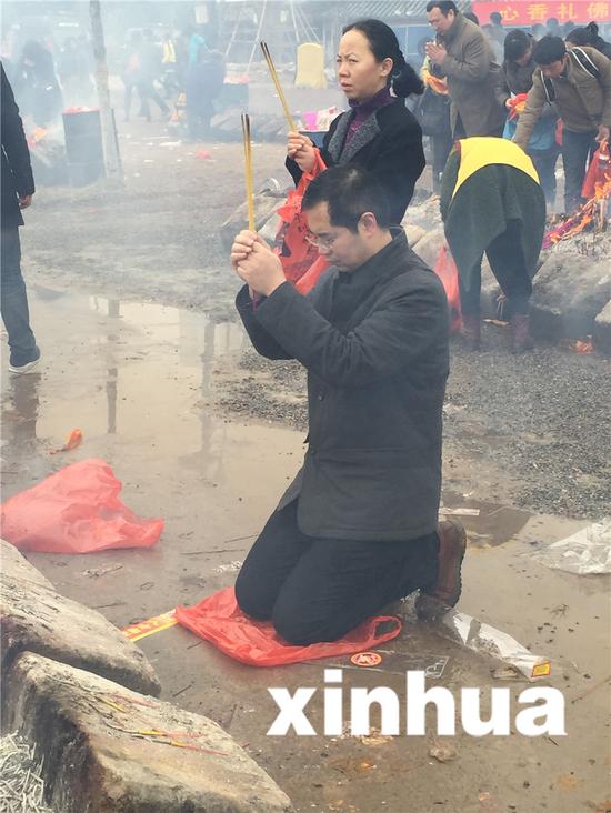 图为：一位市民跪地焚香祈福