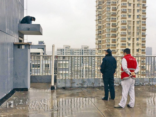 民警与消防队员正在现场劝导欲跳楼的男子