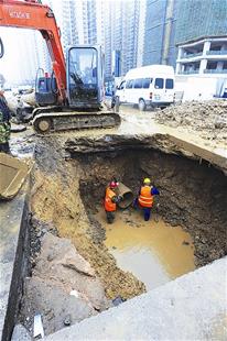 图为：工作人员抢修汉口万安社区附近爆裂的水管