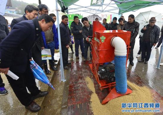 2月27日，新建县西山镇农民在活动上观看农机运转。
