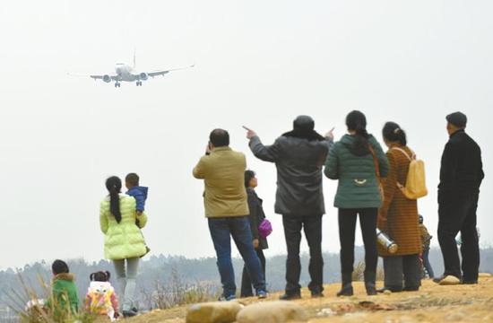 3月2日,二跑道旁市民打堆堆看飞机。