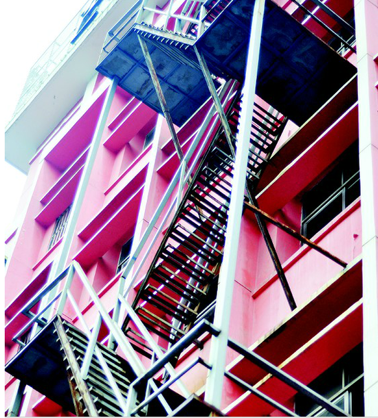 城区东山大道一处酒店，高达五层楼的铁架楼梯安置在临街外墙上。 记者朱敏 摄