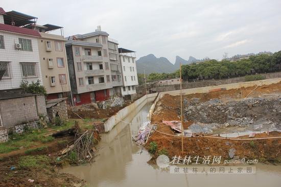 倾斜的房屋旁是一个在建工地。