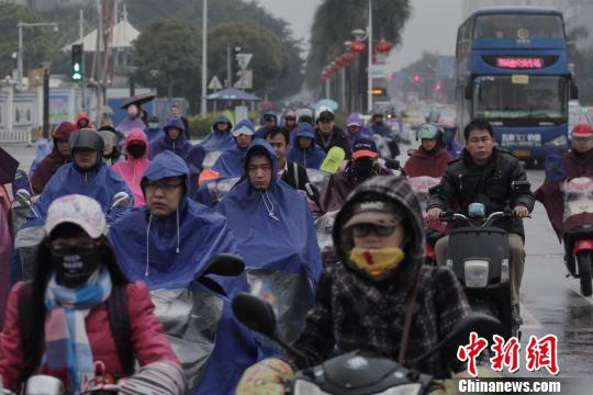 图为10日,南宁街头着厚重御寒“装备”的市民。宋汉涛 摄