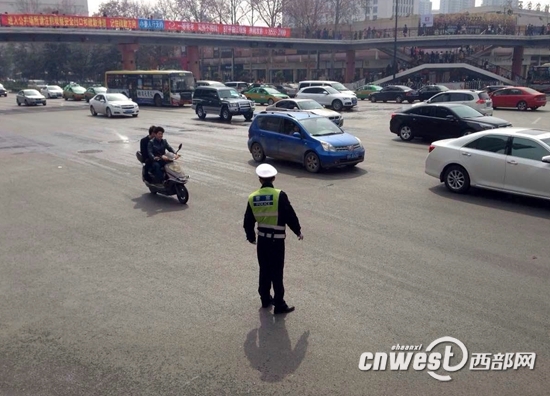 近两日,西安阳光明媚,一位正在执勤的交警的影子被拉的很长。