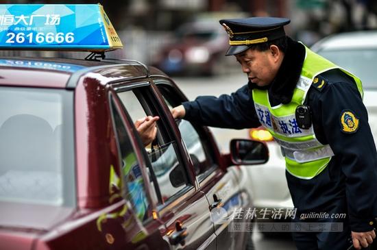 交通执法人员向乘客询问司机是否打表。