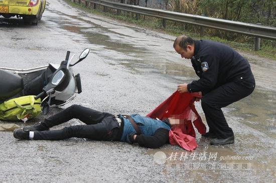 中峰派出所副所长莫堂撕开小龙颈上雨衣瞬间。网友拍摄