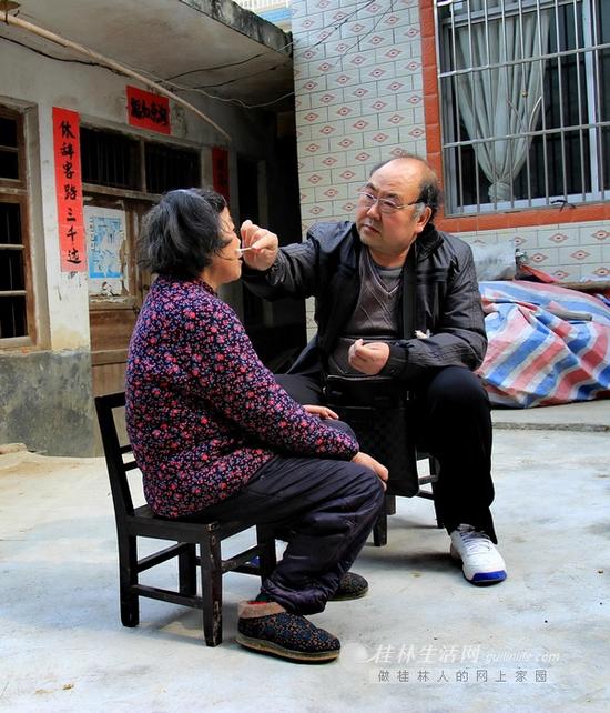 张仁周正给患者擦药。40年来,这样的情形张仁周早就习以为常。