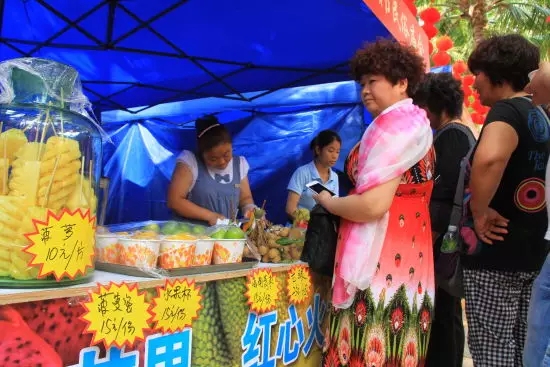 庙会现场,热带水果颇受青睐,图为游客排队买水果