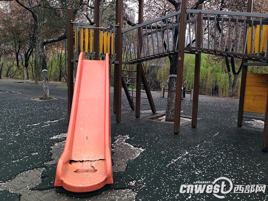 一台儿童游乐设施的滑梯尽头被踩出一个大洞。