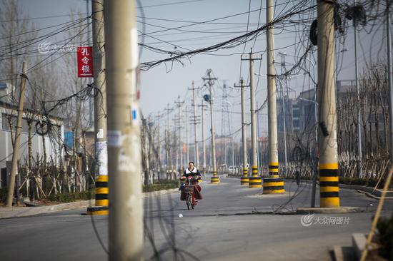 3月23日，济南市天桥区东宇大街北段，蓝翔中路往南至铁路桥附近约800米路段西侧快车道上线杆林立，车辆过往时如同穿行“梅花桩”，险象环生，碰擦事故时有发生。大众网记者 王长坤 摄