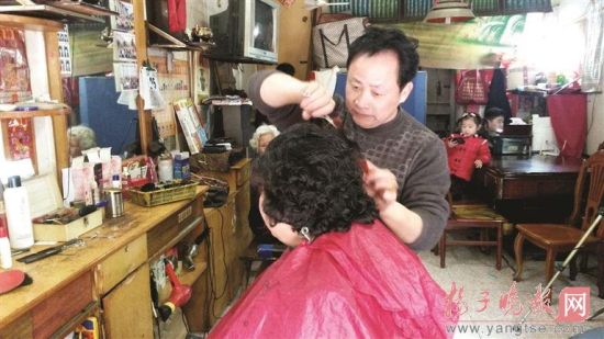 朱洪生在給顧客剪發(fā)