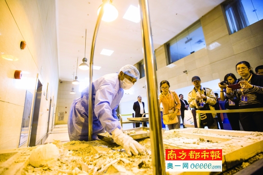 3月27日,广州市殡仪馆公众开放日,市民参观火化车间,一名工作人员在捡灰。