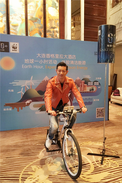 罗中旭骑单车发电点亮“地球一小时”活动LOGO